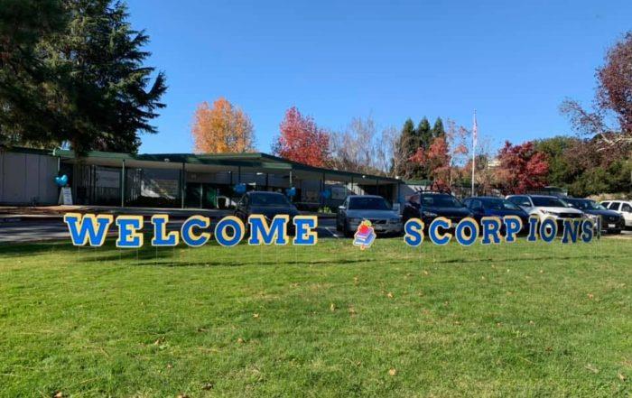 front of school with "Welcome Scorpions" sign