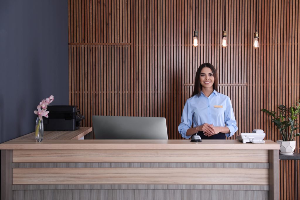 receptionist at wooden front desk