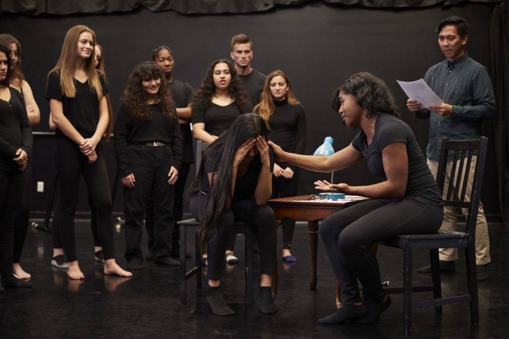 group of students dressed in black doing theatre scene