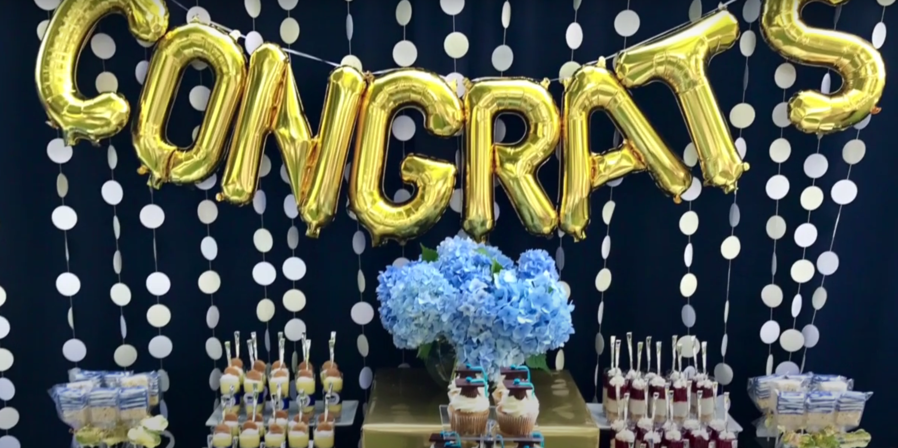 blue and gold party setting with gold congratulations balloons
