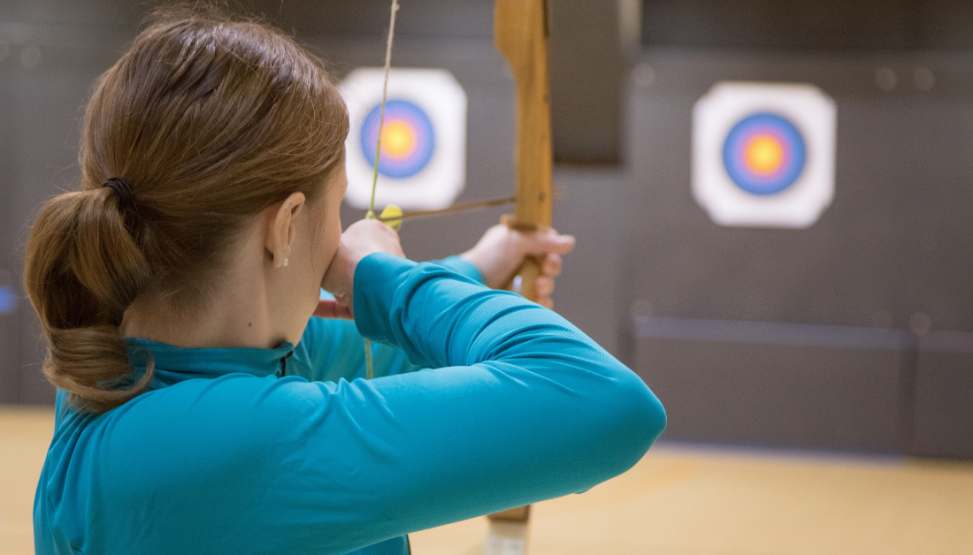girl shooting arrow at target